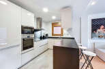 Discover modern living in this stylish kitchen! Featuring sleek, white cabinetry and stainless steel appliances, this space is perfect for culinary enthusiasts.