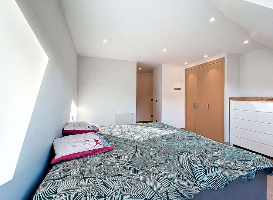 This bright and airy bedroom features a modern design with a comfortable bed and stylish bedding.
