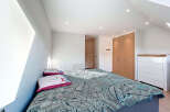 This bright and airy bedroom features a modern design with a comfortable bed and stylish bedding.