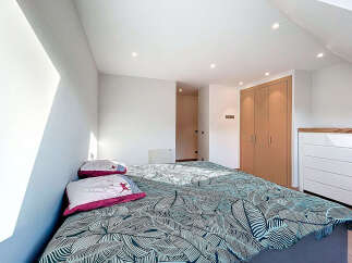 This bright and airy bedroom features a modern design with a comfortable bed and stylish bedding.