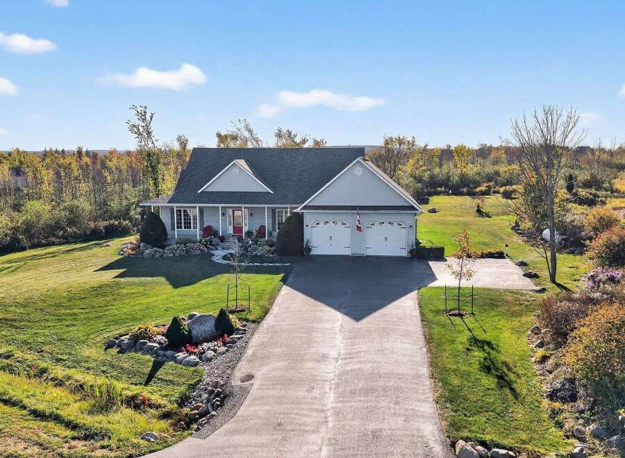 This stunning property boasts a beautiful home with a spacious driveway and a well-maintained lawn.