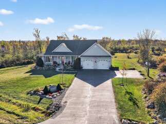 This stunning property boasts a beautiful home with a spacious driveway and a well-maintained lawn.