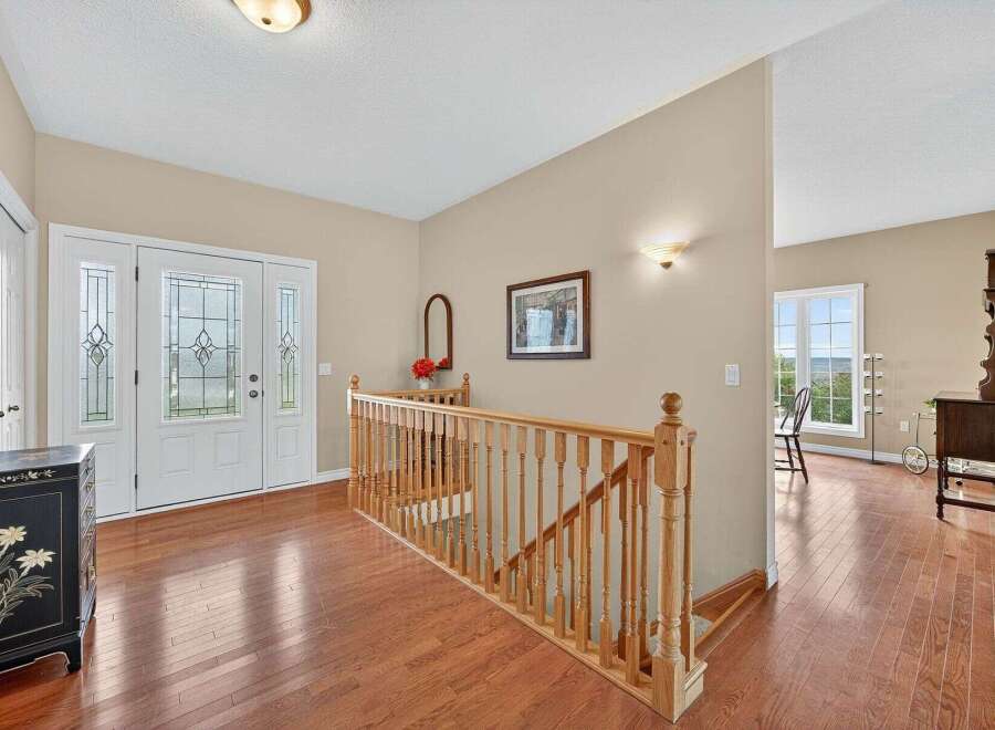 Step into this inviting entryway, showcasing beautiful hardwood floors and a grand staircase.