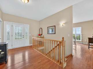 Step into this inviting entryway, showcasing beautiful hardwood floors and a grand staircase.