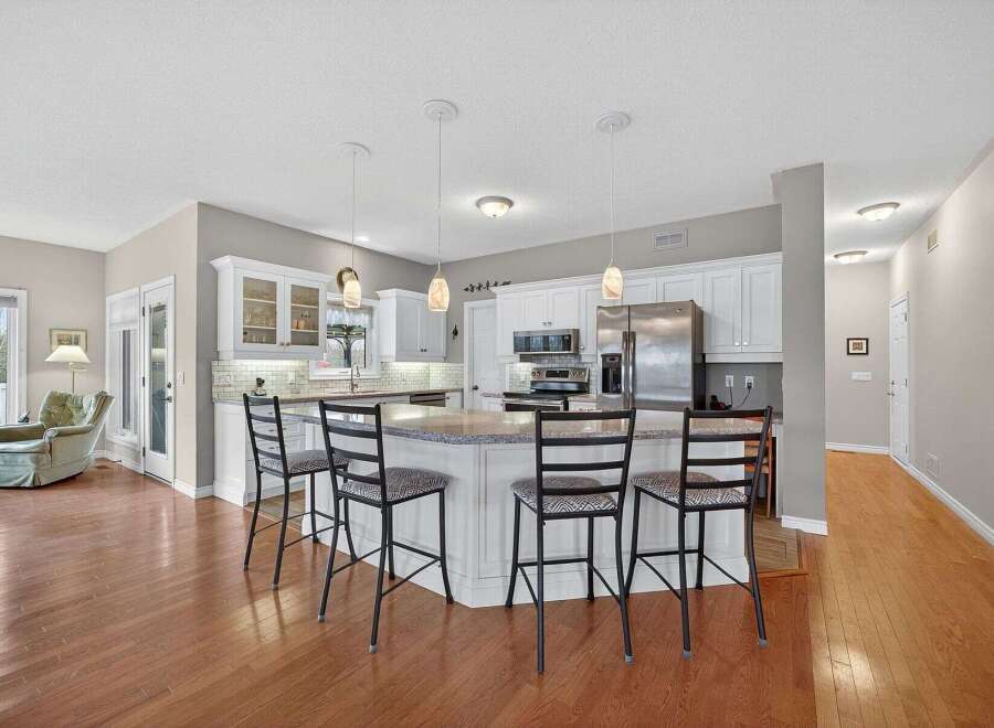 This stunning kitchen boasts a modern design with sleek white cabinetry and a spacious island, perfect for entertaining.