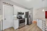 Step into this stunning kitchen, boasting modern stainless steel appliances and elegant white cabinetry.