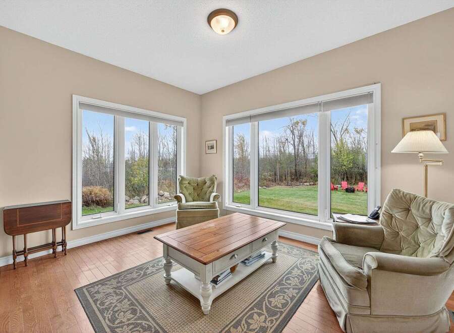 This inviting living space boasts abundant natural light, thanks to the large windows that offer stunning views of the surrounding landscape.
