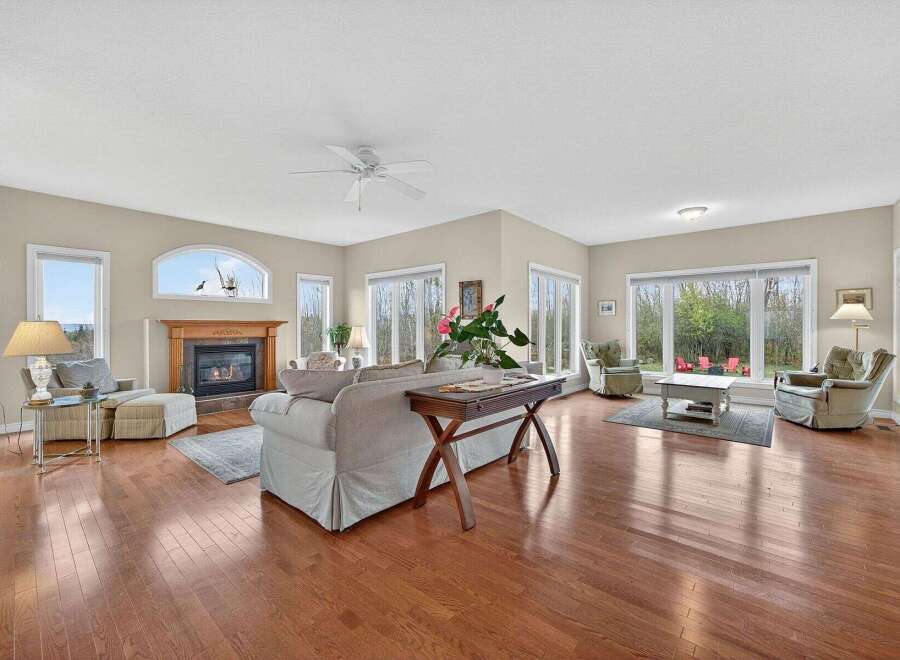 Step into luxury with this stunning living room, boasting a cozy fireplace and elegant hardwood floors.