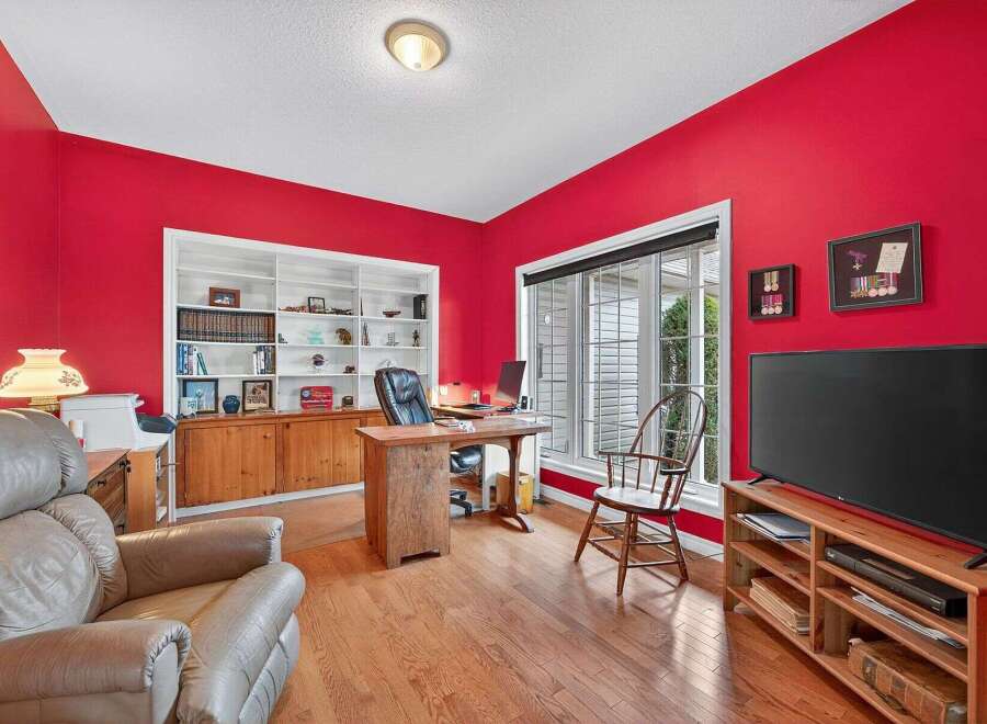This stunning home office boasts a vibrant red wall, creating a bold and inviting atmosphere.