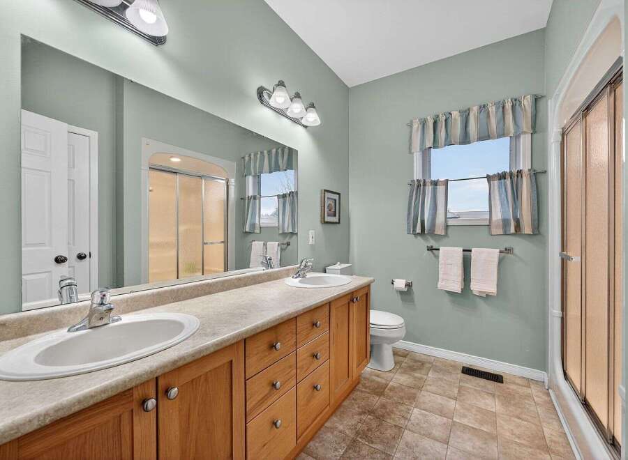 This inviting bathroom showcases a double vanity with ample storage, perfect for a shared space.