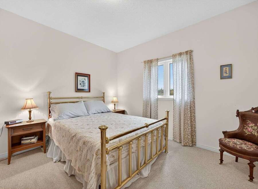 This charming bedroom features a classic brass bed frame, creating a timeless and elegant atmosphere.