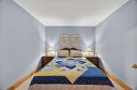 This cozy bedroom features a comfortable bed adorned with a colorful quilt, creating a warm and inviting atmosphere.