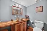 Discover the charm of this unique bathroom design! Featuring a custom wooden vanity with a stylish vessel sink, this space exudes rustic elegance.