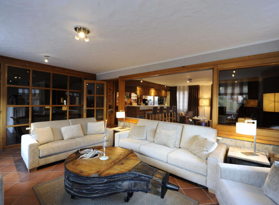 This stunning property boasts a spacious living area with a unique, rustic coffee table as its centerpiece.