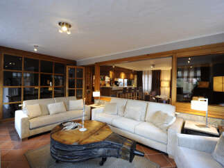 This stunning property boasts a spacious living area with a unique, rustic coffee table as its centerpiece.