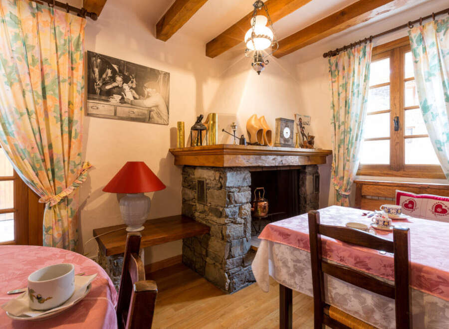 Step into the charm of this cozy property, featuring a rustic fireplace and inviting dining area.