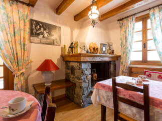 Step into the charm of this cozy property, featuring a rustic fireplace and inviting dining area.