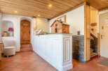 Step into the inviting reception area of this charming property, featuring a rustic wooden ceiling and a welcoming white reception desk.