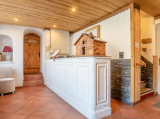 Step into the inviting reception area of this charming property, featuring a rustic wooden ceiling and a welcoming white reception desk.