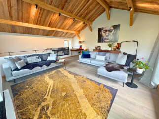This stunning property boasts a spacious living area with a unique wooden ceiling, creating a warm and inviting atmosphere.