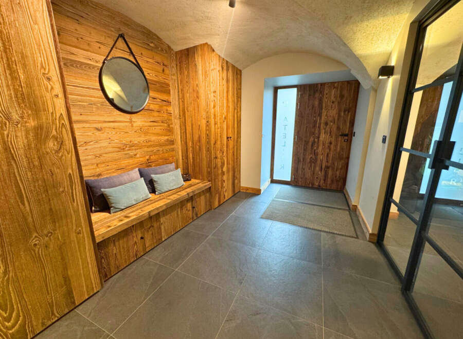 Step into luxury with this stunning entryway featuring exquisite wood paneling and a cozy bench.