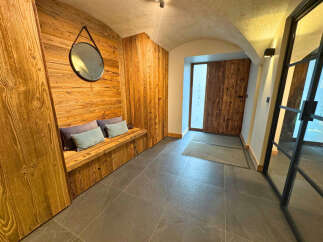 Step into luxury with this stunning entryway featuring exquisite wood paneling and a cozy bench.