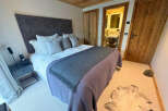 Step into luxury with this stunning bedroom featuring a plush bed, elegant headboard, and stylish decor.