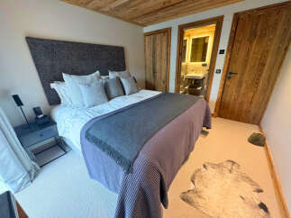 Step into luxury with this stunning bedroom featuring a plush bed, elegant headboard, and stylish decor.
