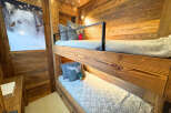 This cozy bunk bed room features beautiful wooden paneling and a charming aesthetic.