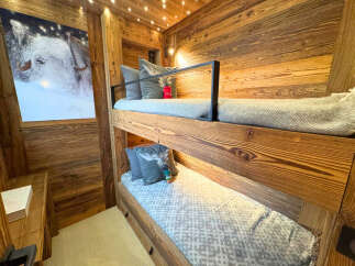 This cozy bunk bed room features beautiful wooden paneling and a charming aesthetic.