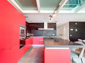 This modern kitchen boasts a sleek design with vibrant red cabinetry, offering ample storage and a bold aesthetic.