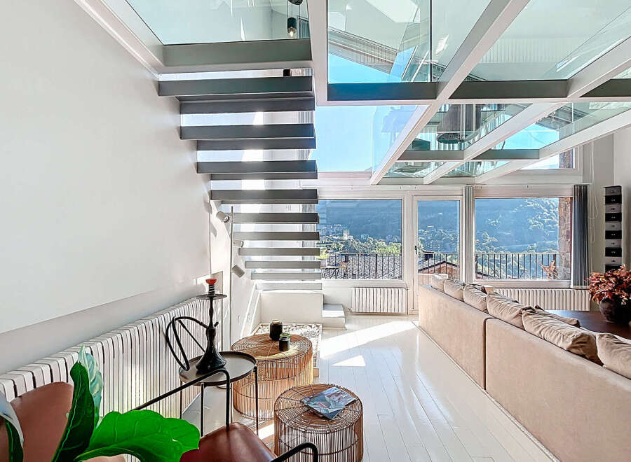 Experience luxury living in this stunning property featuring a modern glass ceiling and sleek staircase.