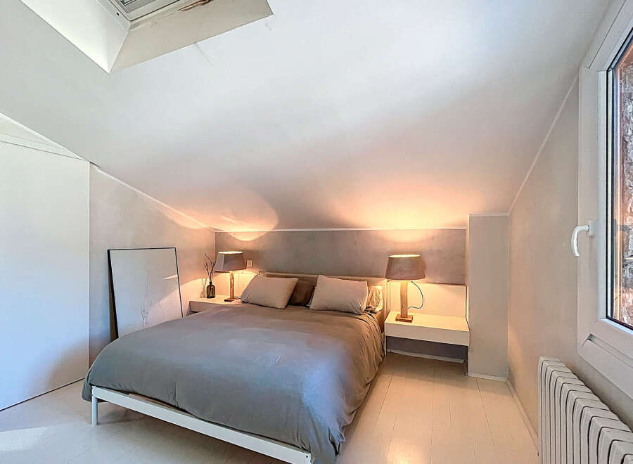 Discover the charm of this cozy bedroom, featuring a comfortable bed and stylish bedside lamps.