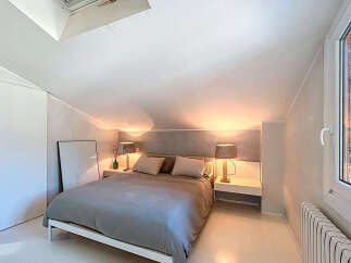 Discover the charm of this cozy bedroom, featuring a comfortable bed and stylish bedside lamps.