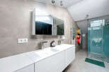 This modern bathroom boasts a sleek, minimalist design with a double vanity and a spacious walk-in shower.