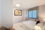 Discover this cozy bedroom featuring a comfortable bed and a stylish artwork.
