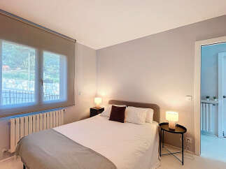This cozy bedroom offers a serene retreat with its neutral color palette and ample natural light.