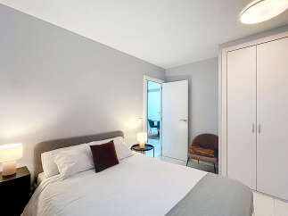 This modern bedroom offers a serene retreat with its minimalist design and neutral color palette.