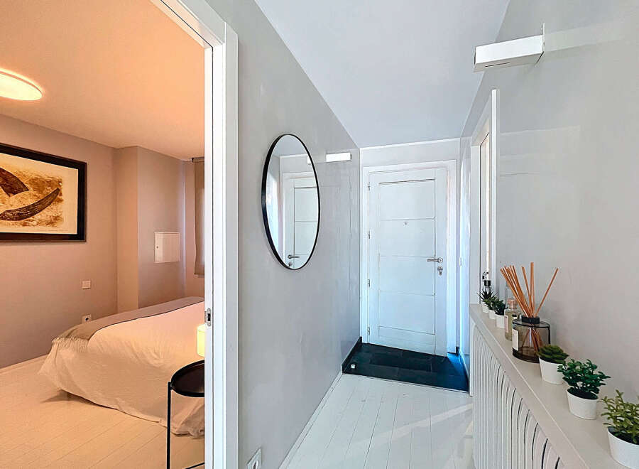 Step into this beautifully designed property featuring a modern hallway with a stylish mirror and a bright, inviting atmosphere.