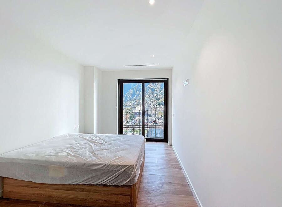 Discover the serenity of this modern bedroom, bathed in natural light and offering stunning mountain views.