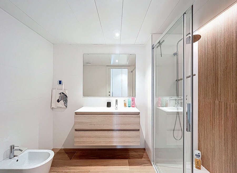 Step into this modern bathroom, featuring a sleek vanity with ample storage and a large mirror.
