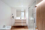 Step into this modern bathroom, featuring a sleek vanity with ample storage and a large mirror.