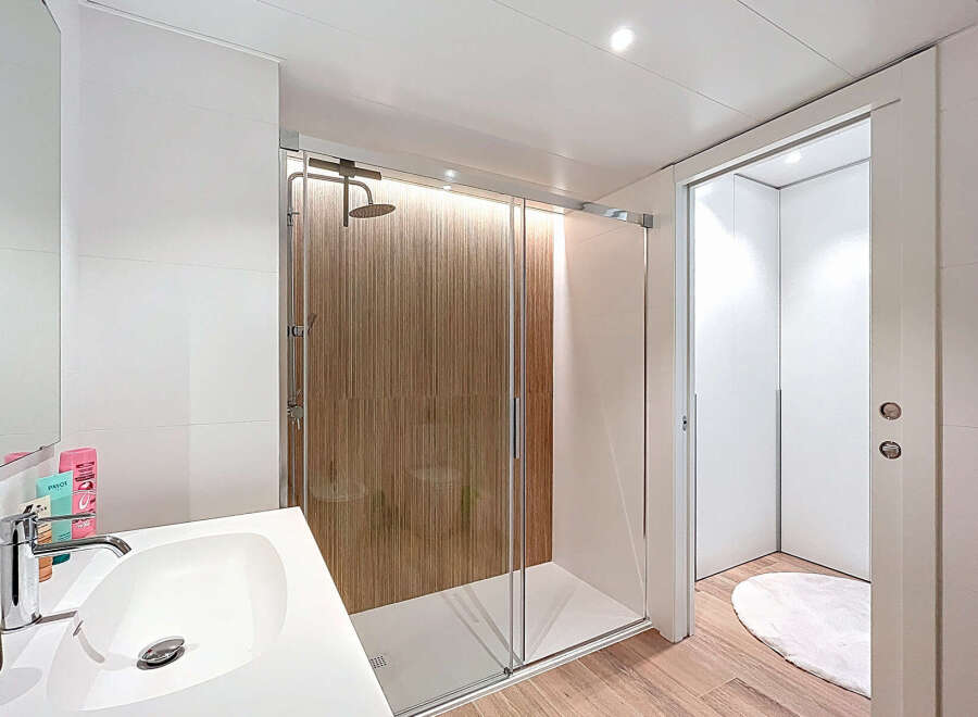 Step into a modern bathroom oasis! This stunning space features a sleek shower with a glass door, complemented by a stylish sink and vanity.