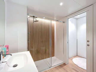 Step into a modern bathroom oasis! This stunning space features a sleek shower with a glass door, complemented by a stylish sink and vanity.