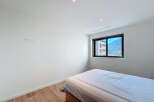 Discover the serenity of this modern bedroom, featuring a large window that frames stunning mountain views.