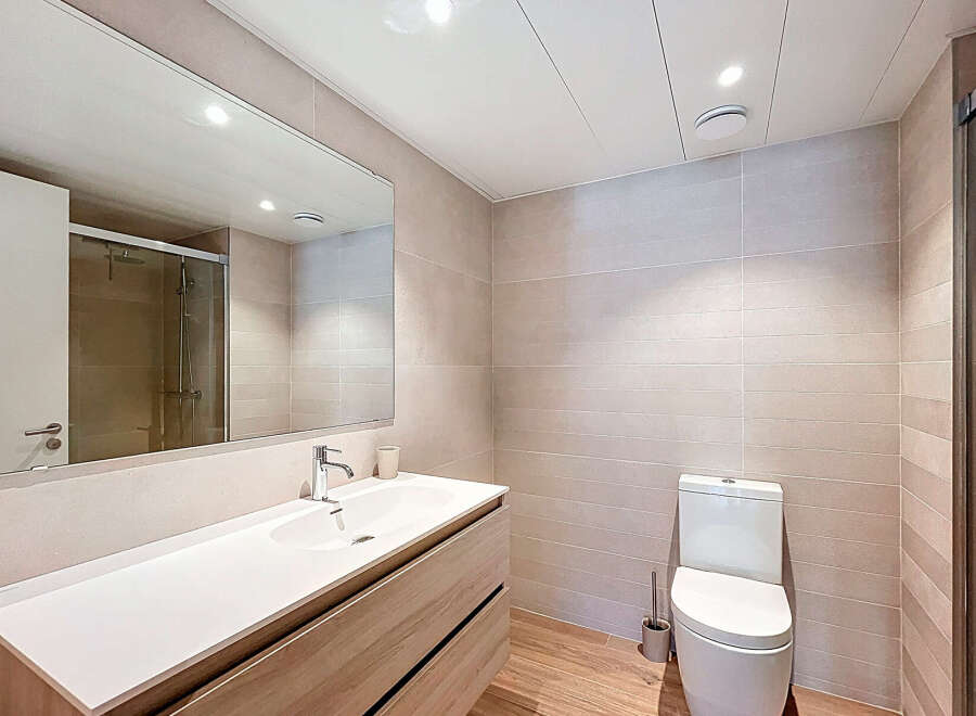 Step into this modern bathroom, featuring a sleek vanity with ample storage and a pristine white countertop.