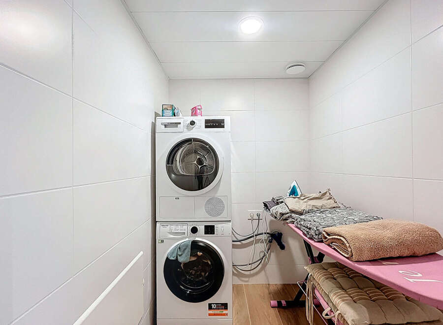 This laundry room offers a functional and organized space for all your washing and ironing needs.