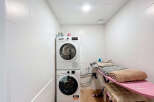 This laundry room offers a functional and organized space for all your washing and ironing needs.