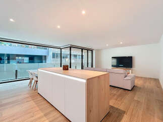 Experience modern living in this stunning property, featuring a sleek kitchen island with integrated lighting and a spacious open-plan layout.