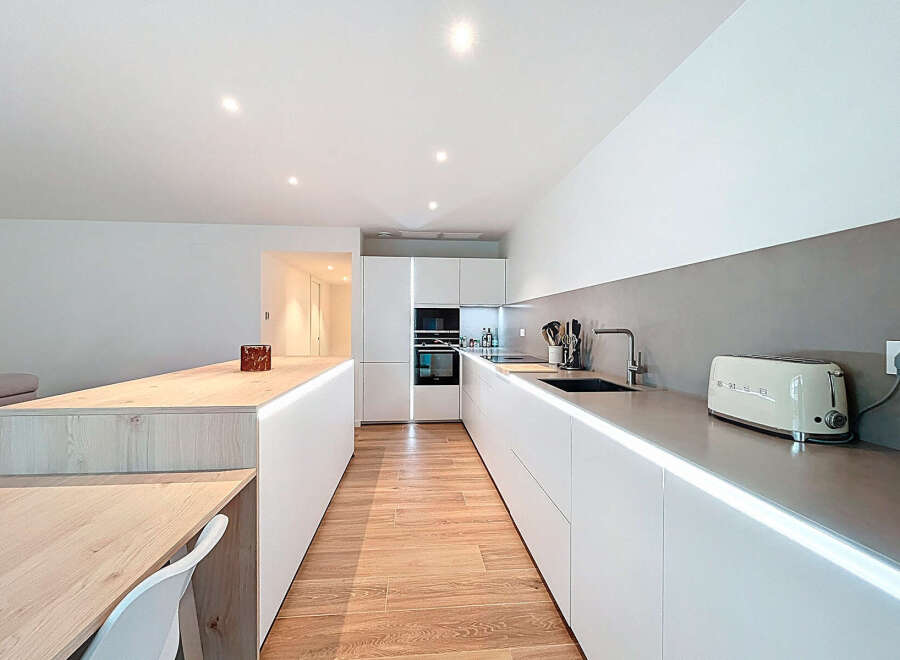 This modern kitchen boasts sleek, minimalist design with clean lines and ample counter space.